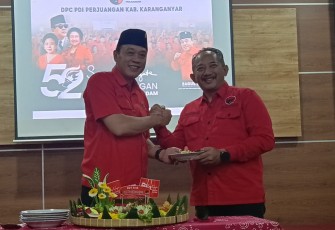 Ketua DPC PDIP Karanganyar Bagus Selo menyerahkan potongan tumpeng kepada Rober Christanto saat perayaan HUT PDIP ke-52, di Kantor DPC PDIP Karanganyar, Jumat (10/1/2024).
