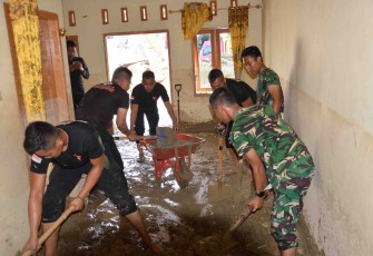 Bersihkan lumpur di dalam rumah warga 