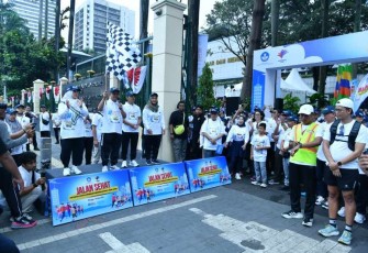 Mendikdasmen Abdul Mu'ti mengibarkan bendera dimulainya jalan sehat Hardiknas 2025 di Jakarta, Minggu (18/5)