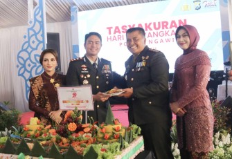 Dandim 0805/Ngawi Letkol Arh Setu Wibowo (kanan) memberikan nasi tumpeng HUT Bhayangkara Ke-79 kepada Kapolres
