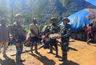 Satgas Yonif 700/Wyc saat menyapa warga dengan senyum dan membawa bahan makanan pokok sebagai bentuk kepedulian dan perhatian.