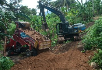 Alat Berat Excavator saat menghampar bahan material sirtu yang di Supali dengan menggunakan dumtruk