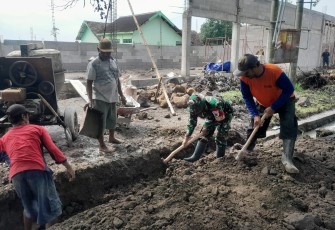 Babinsa dan Warga Tulungrejo saat Gotong Royong Perbaiki Talut di Halaman Koperasi Desa