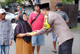 Kapolsek Taman Kompol Kanisius Pranata memberikan makanan dalam kegiatan Jum'at berkah 
