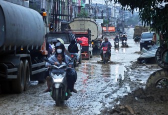 Sejumlah pengendara melintas jalan yang tergenang banjir di Bukit Tempurung, Kota Kuala Simpang, Kabupaten Aceh Tamiang, Provinsi Aceh, Jumat (9/1)