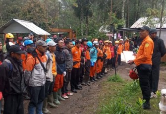 Caption : Komandan Regu Basarnas Surakarta, Tri Puji Sugiarto, memberikan pengarahan kepada personel tim SAR gabungan terkait pencarian lanjutan terhadap Yasid Ahmad Firdaus (26) di Bukit Mongkrang, Gondosuli, Tawangmangu