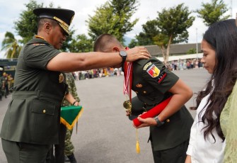 Kasdam XIII/Merdeka saat mengalungkan piagam penghargaan kepada perwakilan prajurit muda yang baru saja di Lantik