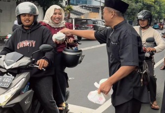 Ketua Koordinator Wilayah Malang Raya, Aries Pratomo, saat tengah membagikan takjil gratis kepada pengendara yang melintas, Minggu (15/3)