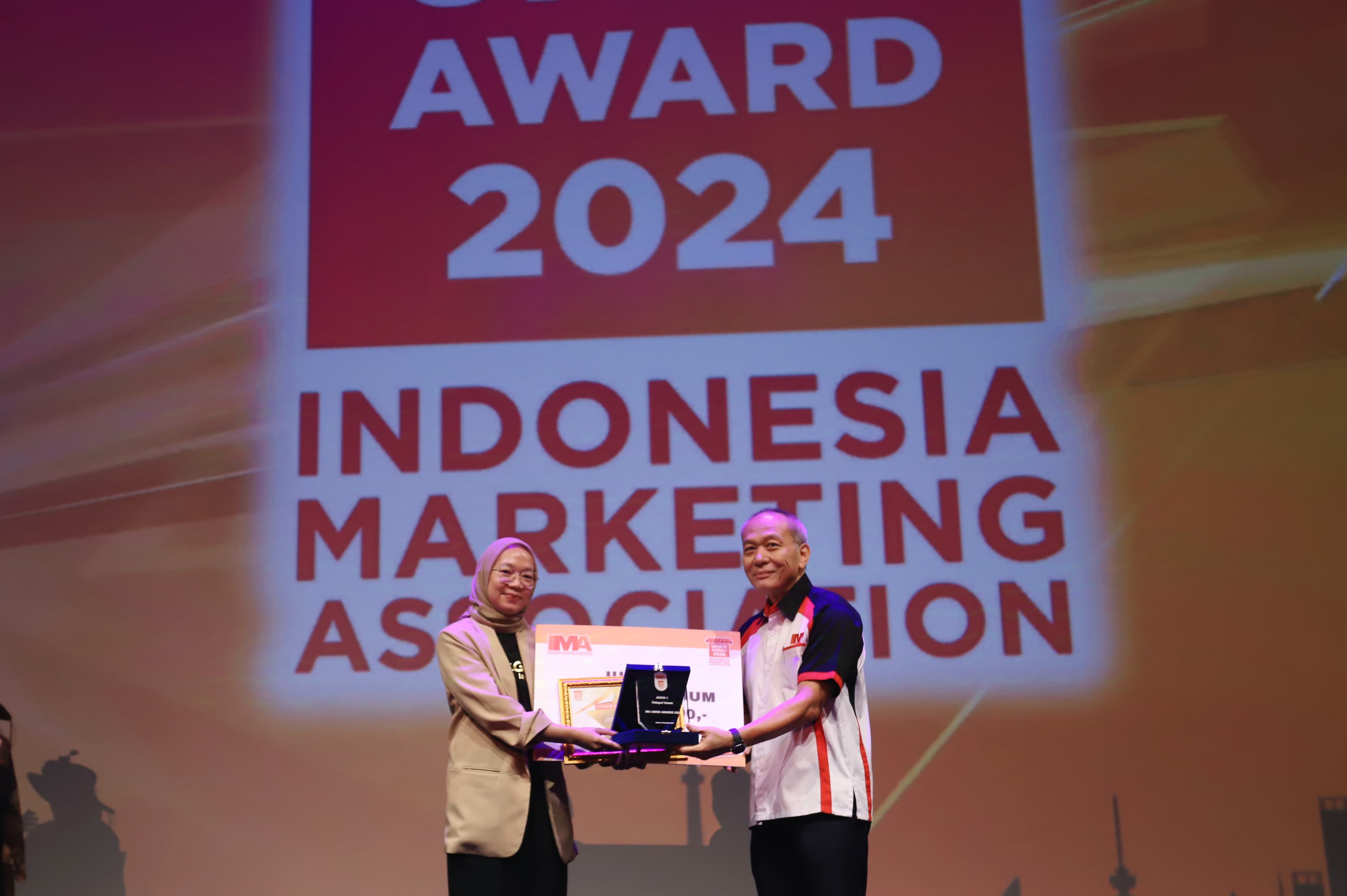 Penyerahan hadiah juara 1 IMA UMKM Award 2024 secara simbolis oleh President IMA, Suparno Djasmin (kanan), kepada Irena Surosoputro (kiri) sebagai CEO Cokelatin Signature.