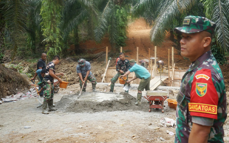 (Gotong royong pengecoran plat duiker. Dansatgas Letkol Inf. Aswin memastikan pekerjaan lancar)