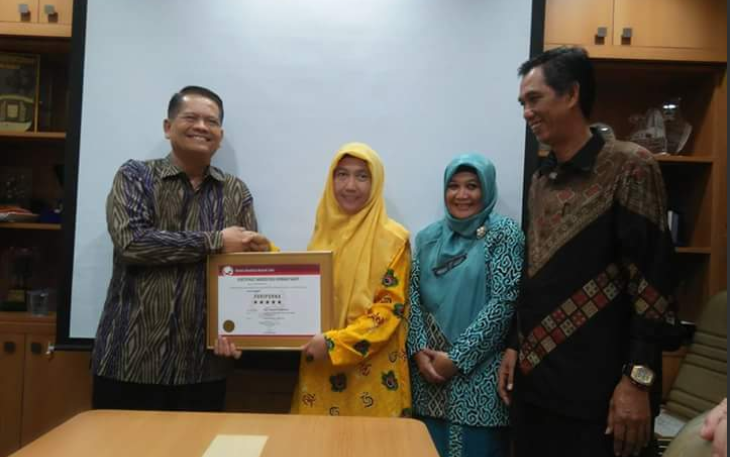 Direktur RSKJ Soeprapto Bengkulu, Chandrianiy Puri saat menerima sertifikat akreditasi paripurna dari Direktur Eksekutif KARS Sutoto, Senin (05/01/2018).  