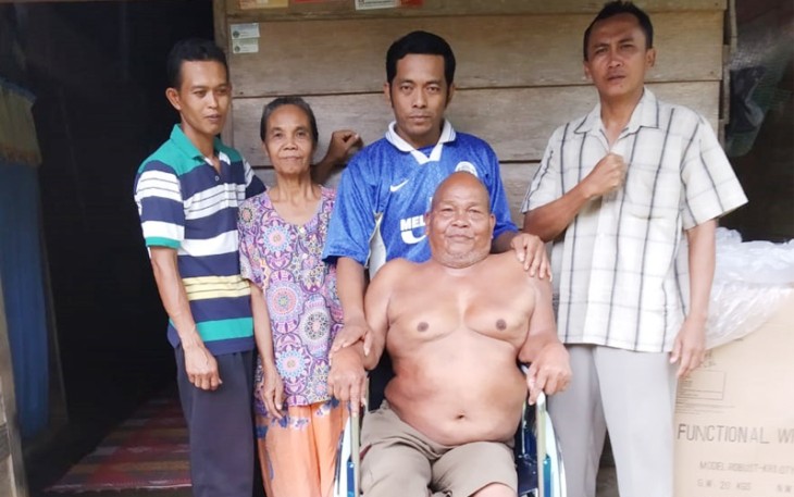 Dukut Sumari S.IP, Kades Melati Harjo didampingi Ketua RT Joko Suprapto dan Tokoh Masyarakat Waluyo, Selasa (11/12/2018) saat menyalurkan bantuan kursi roda di kediaman Pak Men.