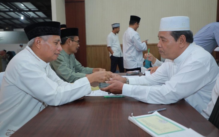 Plt. Bupati Asahan, Surya saat  menyerahkan ZIS kepada Baznas Kabupaten Asahan.