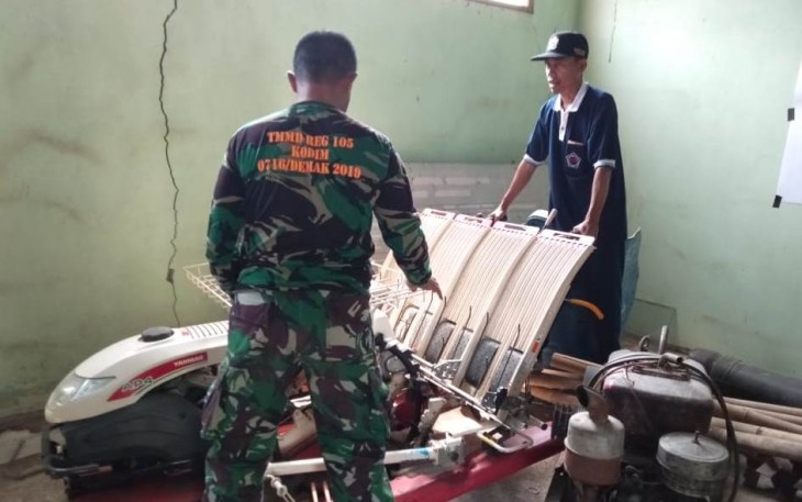 Tentara Satgas Beri Bimbingan Warga Tentang Alat Tanam Padi Modern 