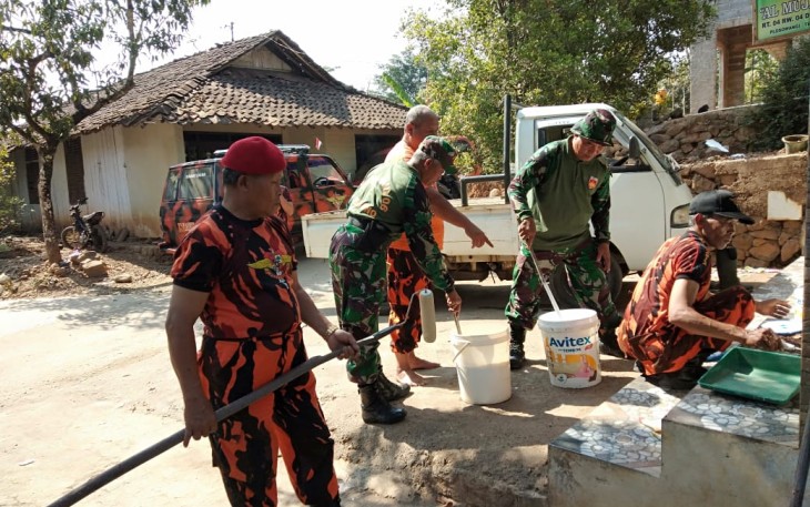 Anggota Koramil 06/Tersono bersama Pemuda Pancasila PAC Tersono saat mengecat dinding Musholla Almujahidin