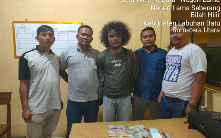 Tersangka (tengah) saat diamankan beserta barang bukti