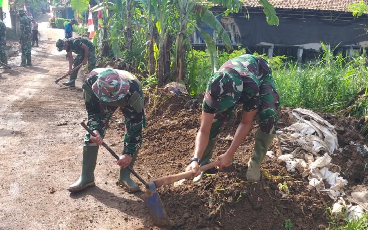 Satgas TMMD Bersihkan Tanah di Bekas Drainase 