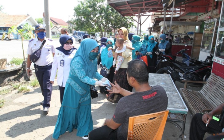 Ketua Tim penggerak PKK Kota Lhokseumawe Cut Ernita membagikan masker kepada warga masyarakat  di Terminal Bus Tipe A Kota Lhokseumawe Jumat (10/4)