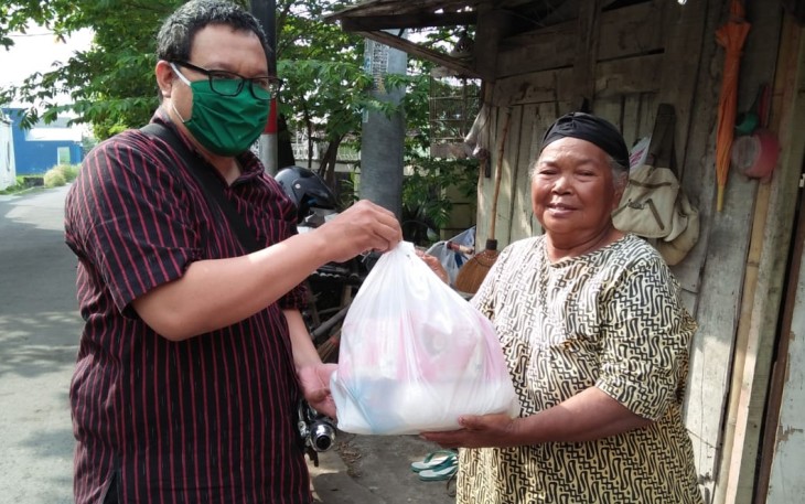 Pihak Baitul Maal Muhammadiyah Kottabarat Solo sedang menyalurkan paket sembako kepada warga.