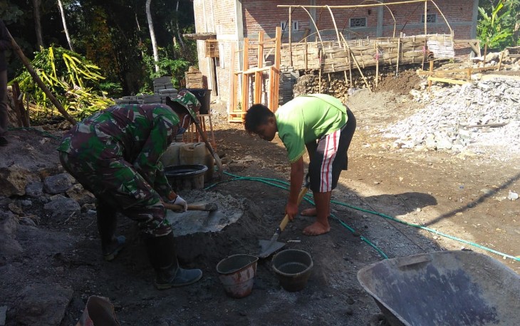 Karyono Bantu Satgas Aduk Semen dalam Membangun Rumahnya