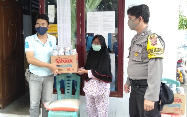 Lurah Manembo-nembo Tenga Gheraldo Lolombulan didampingi bhabinkamtibmas salurkan bansos ke warga
