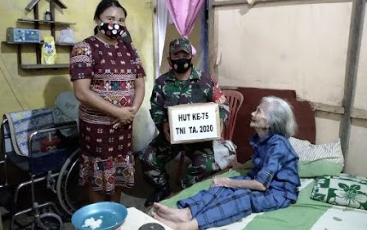 Babinsa Danowudu Serka James Posumah bersama istri saat berikan talk asih dari kodim ke ibu janda purnawirawan TNI