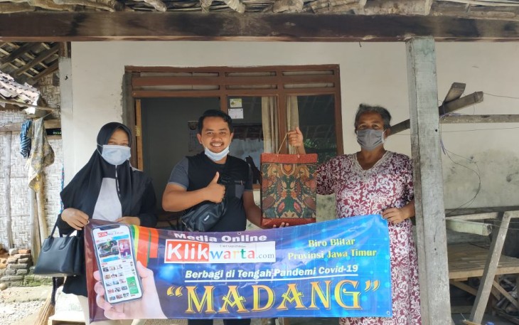 Kepala Biro Klikwarta.com Blitar Faisal Nur Rachman (tengah) Didampingi Istri (Ervin Rachman / kiri) Menyalurkan Sembako kepada Penerima Manfaat (foto: Reni Kurnia / Klikwarta.com) 