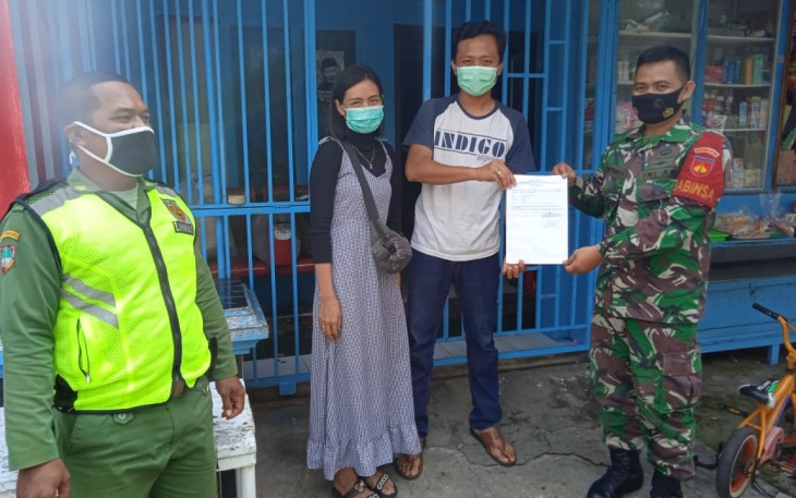 Anggota TNI dari Koramil 04/Jebres Kodim 0735/Surakarta Serka Suryanto yang saat ini menjabat sebagai Babinsa Kelurahan Sewu membantu pemulangan warganya usai melaksanakan karantina di Asrama Haji Donohudan, Sabtu (30/1/2021).