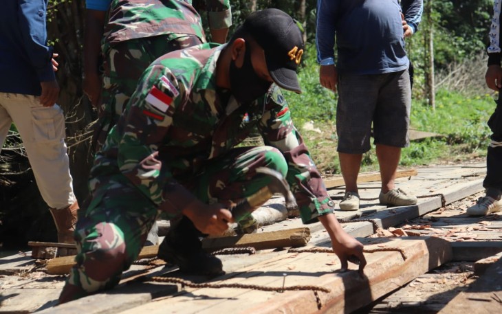 Satgas Pamtas RI-MLY Yonif 407/PK bersama warga memperbaiki jembatan yang rusak di Dusun Perumbang, Desa Kekurak, Kec. Badau, Kab. Kapuas Hulu, Kalimantan Barat.