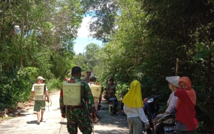 Babinsa Bersama Masyarakat Desa Binaannya Gotong Royong Melakukan Penyemprotan Jalan