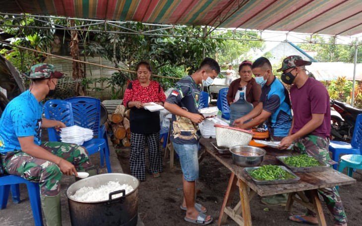 Personil satgas TMMD bersama warga bahu membahu menyiapkan makan siang
