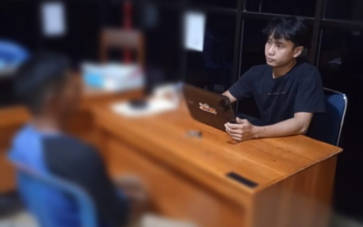 Tersangka (kaos biru) saat diperiksa penyidik