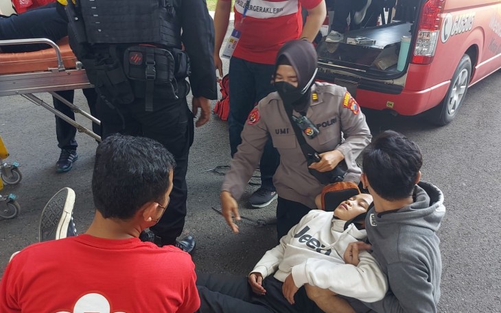 Polisi saat membantu salah seorang sporter