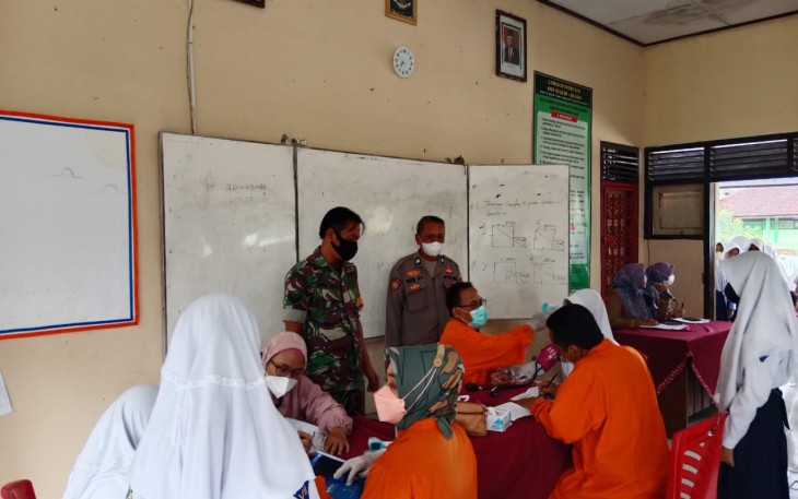 Babinsa dan Polsek Blado, laksanakan Pendampingan dan Monitoring Vaksinasi Covid-19 476 Siswa/Siswi SMPN 1 Blado, di gedung SMP N 1 Blado