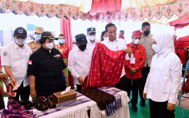 Presiden RI Joko Widodo saat mencoba kain tradisional di salah satu stand UMKM