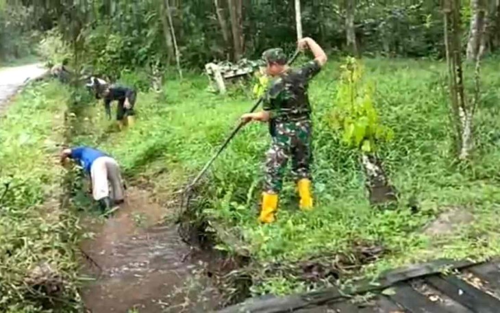 Serka Irfan saat membersihkan saluran air