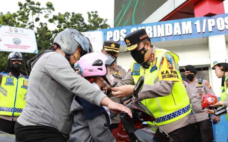 Kapolda Riau Irjen Pol Mohammad Iqbal saat berikan helm dan memakaikannya ke anak pengendara motor. Selasa (4/10)