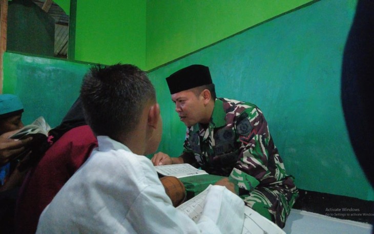 Prajurit Ajusta saat Ajarkan Mengaji pada Anak-anak di Daerah Penugasan   