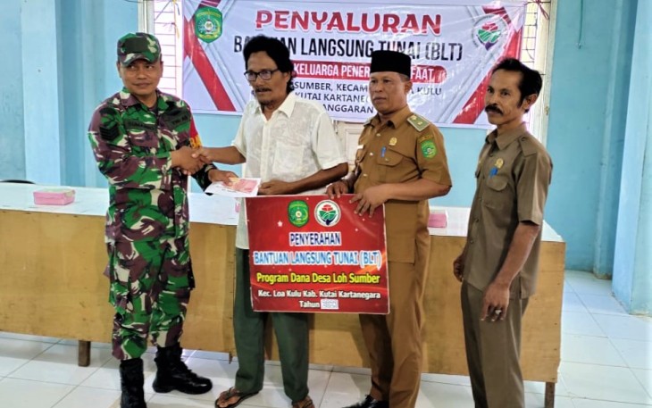 Babinsa Loh Sumber, Koramil 0906-02/Loa Kulu, Kodim 0906/Kkr Serka Sumarno saat melakukan pendampingan dalam kegiatan penyaluran BLT.