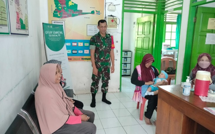 Babinsa Koramil 0803-09/Saradan Sertu Sunarwan saat Dampingi Imunisasi Bagi Anak