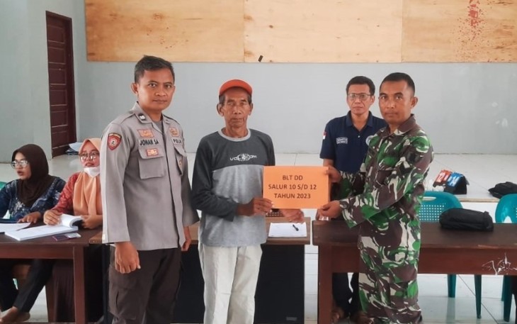 Sinergitas Babinsa Bersama Bhabinkamtibmas Berikan Pendampingan Dalam Penyaluran BLT