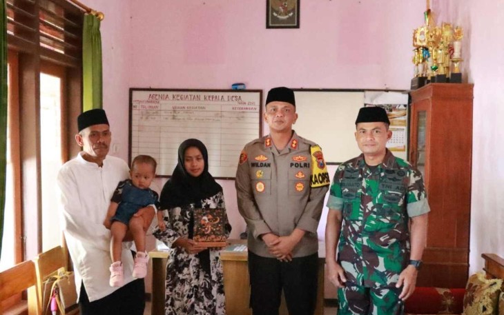 Dandim 0801/Pacitan Letkol Inf Roliyanto foto bersama keluarga alm Praka Miftahul Arifin usai memberikan santunan