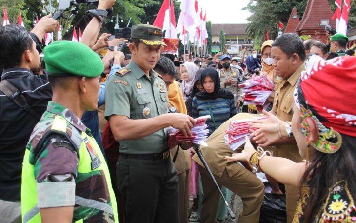 Dandim 0806/Trenggalek Letkol Kav Peddy Adi Prasetyo saat membagikan bendera merah putih ke masyarakat, Senin (31/7)