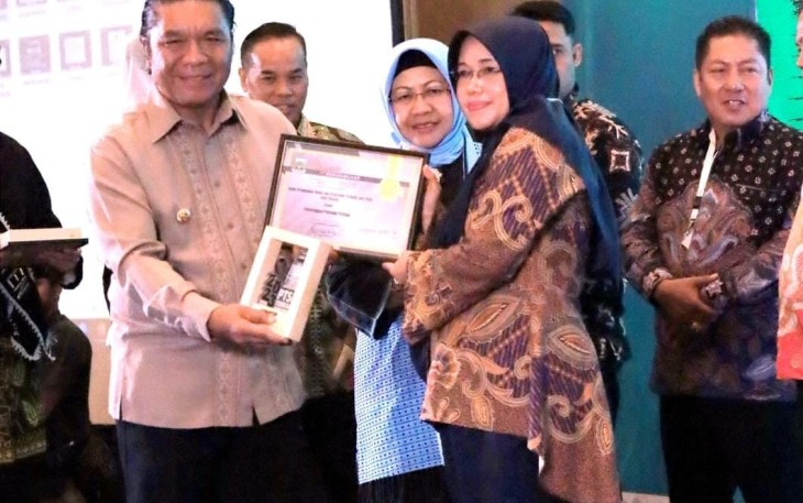 Pj Gubernur Banten Al Muktabar saat menyerahkan penghargaan kepada Kepala DPMPTSP Kota Cilegon Hayati Nufus, Kamis (19/10)