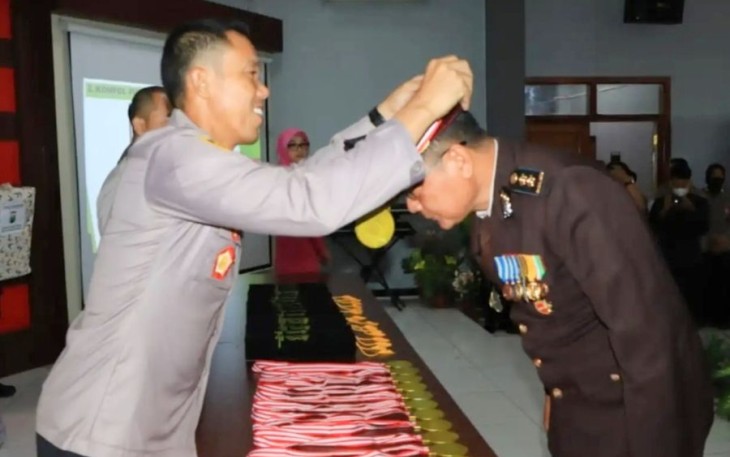 Kapolres Tuban AKBP Rahman Wijaya saat mengalungkan medali wisuda purna bhakti personelnya, Selasa (3/1)