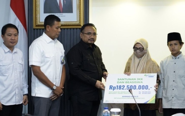 Menag Yaqut Cholil Qoumas menyerahkan secara simbolis klaim Petugas Pembimbing Ibadah Haji tahun 2023 dari BPJS Ketenagakerjaan kepada Khanatus Sa'diah, Selasa (15/8) 