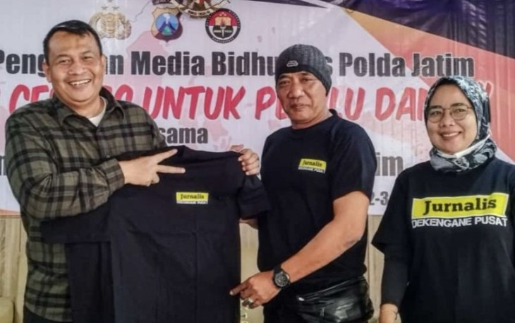 Kabid Humas Polda Jatim Kombes Dirmanto saat memberikan baju saat sarasehan media bersama jurnalis di Kota Batu, Minggu (3/9)