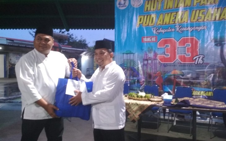 Dirut PUD Aneka Usaha, Samidi, menyerahkan paket sembako kepada salah satu warga di sela acara HUT ke-33 PUD Aneka Usaha, di areal wahana wisata Water Park Intan Pari Karanganyar, Minggu (26/3/2023).