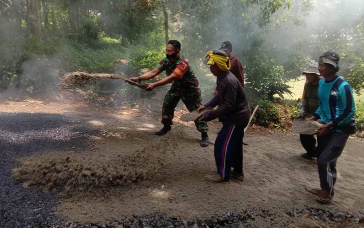 Babinsa Segulung Sertu Budi, disela kesibukannya membantu pengaspalan jalan di lingkungan Dusun Glatik RT 24, RW 09 Desa Segulung, Kecamatan Dagangan, Kabupaten Madiun, Sabtu (16/9/2023).