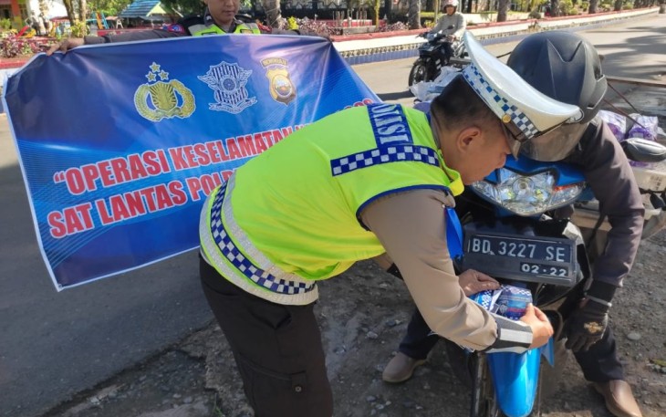 Polantas saat pasang stiker himbauan keselamatan berlalu lintas